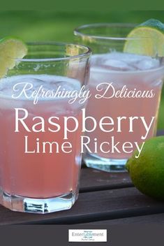 two glasses filled with raspberry lime rickey on top of a wooden table