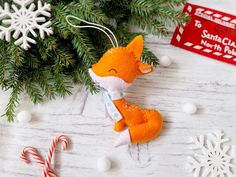 an ornament with a red fox on it next to some candy canes