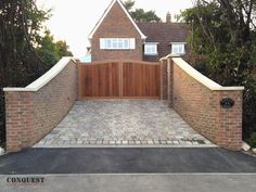 a large brick driveway with a wooden gate