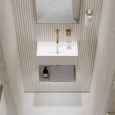 a white sink sitting under a bathroom mirror next to a wall mounted faucet