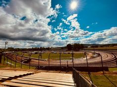 the sun shines brightly over an empty track at a race course in rural australia