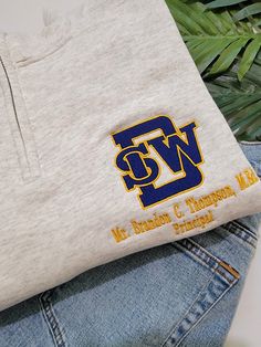 Southwest DeKalb High School Logo Shirt Show your Panther pride with our custom-embroidered Southwest DeKalb High School Logo Shirt! Featuring the iconic SWD logo in bold blue and gold, this shirt is perfect for students, alumni, and supporters alike. The logo is meticulously embroidered on the left chest, ensuring a polished and durable finish that stands the test of time. Make it uniquely yours by adding your name underneath the logo for a personalized touch. Whether you're heading to class, cheering on the team, or just want to represent your school spirit, this shirt has you covered. Choose from a variety of styles to suit your preference: 1/4 Zip: Ideal for layering, with a versatile neckline that adds a sporty flair. Polo Shirt: A classic choice for a clean and sophisticated look. Cr Cheap Classic School T-shirt, Casual Team Name Shirt Cheap, Cheap College T-shirt With Embroidered Logo, High School Shirt Designs, Yearbook Committee, School Merch, Panther Pride, School Shirt Designs, American High School