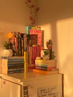 a white refrigerator freezer sitting next to a stack of books on top of a counter