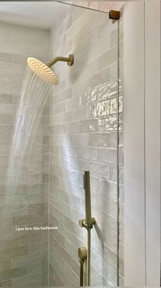 a shower head and hand shower in a white tiled bathroom with gray tile on the walls