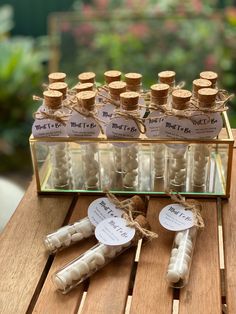 some bottles are sitting on a wooden table with tags attached to them and tied together