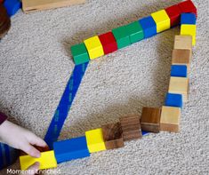 a child playing with wooden blocks on the floor