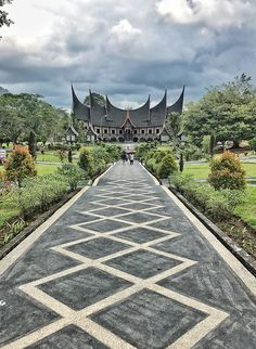 the walkway is made out of cement and has geometric designs on it, as well as trees