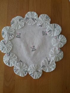 a white doily with words written on it sitting on top of a wooden table