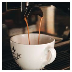 coffee being poured into a white cup