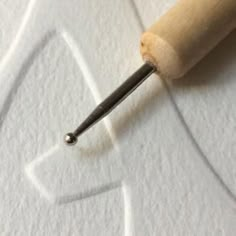 a close up view of a wood handle on a piece of paper with a hole in it