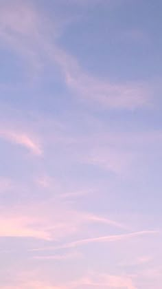 two people standing on the beach flying a kite in the sky at sunset or dawn