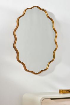 a mirror hanging on the wall next to a dresser