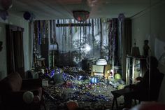 a room filled with balloons and confetti all over the floor in front of a window