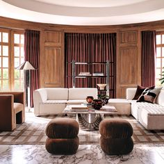 a living room filled with lots of furniture next to two large brown and white couches