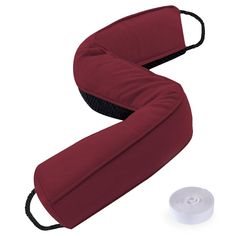 a red neck pillow next to a roll of white thread on a white background with an object in the foreground