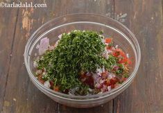 a glass bowl filled with chopped vegetables on top of a wooden table