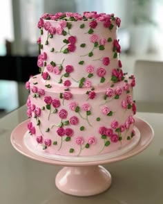 a three layer cake decorated with pink roses