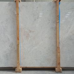 two pieces of white marble sitting on top of each other in front of a wall