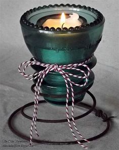 a green glass bowl with a candle inside