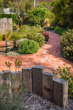 a brick walkway in the middle of a garden