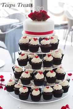 cupcakes are stacked on top of each other in front of a wedding cake