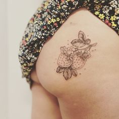 a woman's back with a tattoo on the side of her body and flowers around it