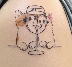 a cat with a wine glass tattoo on it's back leg and another cat behind it