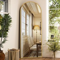 a large mirror sitting on top of a wooden floor next to a table and chair