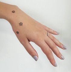 a woman's hand with flowers tattooed on it