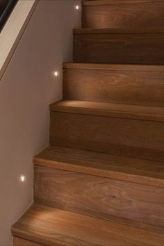 the stairs are made of wood and have white lights on them, as well as an alarm clock