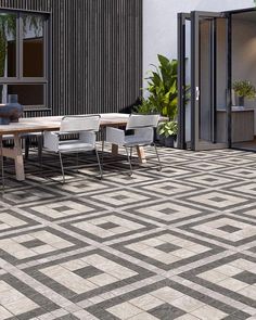 an outdoor dining table and chairs on a tiled patio with potted plants in the background