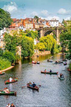 many people are rowing boats down the river