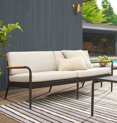 a couch sitting on top of a rug next to a pool