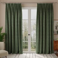 a living room scene with focus on the curtains and the sliding glass door that leads to an outside patio