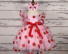 ### Product Description Our enchanting Strawberry Pattern Dress for children, crafted from luxurious tulle, satin, and organza, and adorned with delicate pearls. This knee-length dress is perfect for making your little one feel like a princess. The full set includes a beautifully designed dress, a matching headband, and a pair of red shoes.  This dress is ideal for various special occasions, including: - Birthday parties - Family gatherings - Weddings - Holiday celebrations - Photo shoots - Scho Pink Tulle Tutu Dress For Christmas, Berry First Birthday Dress, Summer Organza Princess Dress For Dress-up, Pink Ruffled Tutu Dress For Christmas, Pink Ruffled Christmas Tutu Dress, Pink Christmas Tutu Dress With Ruffles, Christmas Pink Ruffled Tutu Dress, Fitted Red Tutu Dress For Spring, Cute Pink Tutu Dress For Christmas