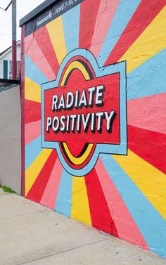 a colorful wall with the words radiate positivity painted on it's side