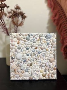 a card with shells and seashells is on a table next to some dried flowers