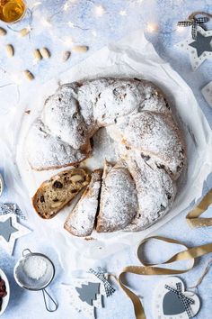 a bundt cake with powdered sugar on top and other desserts around it