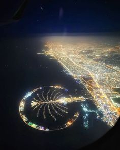 an aerial view of the city lights at night taken from inside an airplane in flight