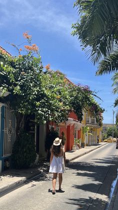 a woman walking down the street with a hat on