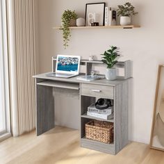 a laptop computer sitting on top of a wooden desk next to a potted plant