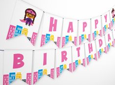 a happy birthday banner hanging on the wall next to a white wall with pink and blue buildings