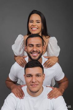 three people posing for the camera with their arms around each other and one person holding another man's shoulders