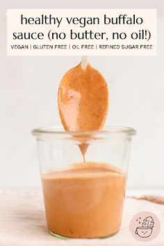 an image of a spoon full of vegan peanut butter on top of a glass bowl