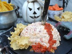 a black plate topped with tortilla chips and salsa