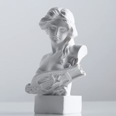 a white marble busturine with a guitar in it's mouth and eyes closed