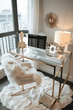 a desk with a chair and computer on top of it in front of a window