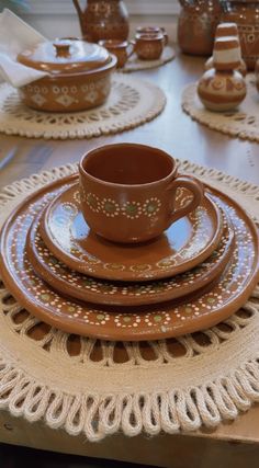 a table topped with lots of brown plates and cups