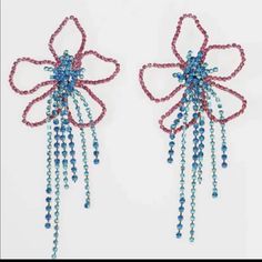 two pairs of beaded earrings with blue and red beads hanging from the ends of each ear