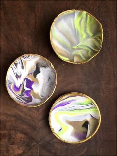 three bowls sitting on top of a wooden table next to each other with different designs